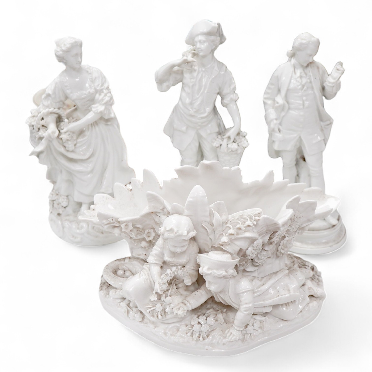Three Continental white glazed figures and an English bone china group, tallest 25cm